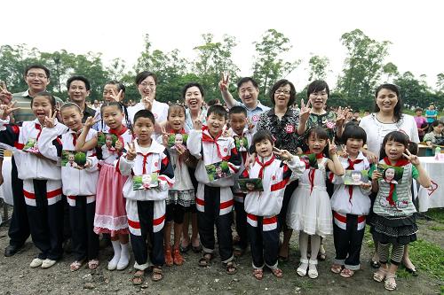 6月29日,在在四川省眉山市洪雅縣,符場中心小學(xué)的留守兒童與全國婦聯(lián)及聯(lián)合利華的工作人員在揭牌儀式上合影。新華社記者 任正來 攝
