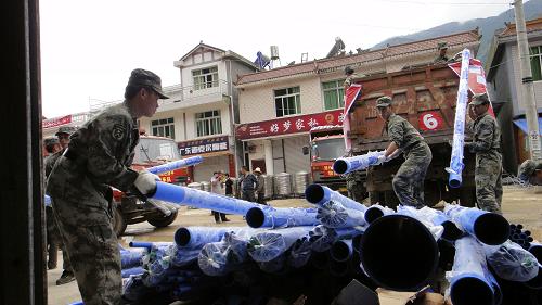 8月23日,在四川綿竹市清平鄉(xiāng)清平場鎮(zhèn),救援人員在卸載一批經(jīng)德(陽)阿(壩)公路運(yùn)進(jìn)災(zāi)區(qū)的水管。新華社發(fā)(王平 攝)