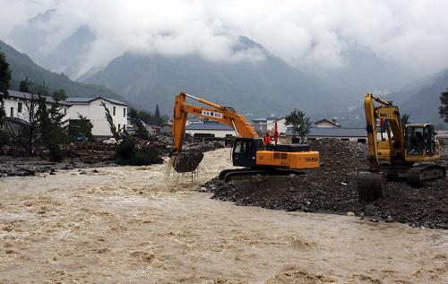 8月23日,在四川綿竹市清平鄉(xiāng),經(jīng)過搶通的德(陽)阿(壩)公路進(jìn)入災(zāi)區(qū)的機(jī)械設(shè)備在清除河道中的泥石流堆積物。 經(jīng)過搶通突擊隊(duì)10天的奮戰(zhàn),22日21時(shí)30分,通往清平鄉(xiāng)的德阿公路漢清段基本搶通。四川在“8·13”特大洪水泥石流災(zāi)害中的最后一個(gè)“孤島”被打通。23日,德阿公路漢清段順利實(shí)現(xiàn)通車,救災(zāi)物資首次經(jīng)陸路運(yùn)抵清平災(zāi)區(qū)。這批物資主要包括生活物資、搭建板房的板材、飲用水管材、防洪應(yīng)急材料等。 新華社發(fā)(王平 攝)