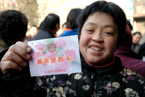 12月14日,太原市朝陽三社區(qū)的一位居民在展示她的“慈善愛心卡”。