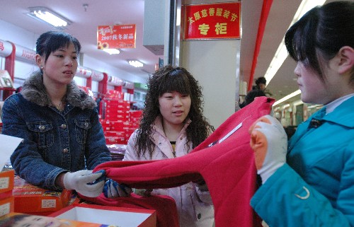 12月14日,市民在太原市一服裝市場的“慈善服裝節(jié)專柜”挑選衣服。