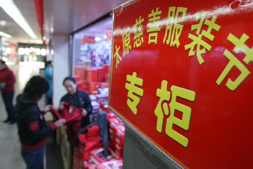 12月14日,市民在太原市一服裝市場的“慈善服裝節(jié)專柜”挑選衣服。