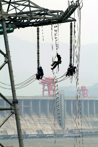 建設(shè)者在三峽大壩前架設(shè)電力輸送線路(2007年5月25日攝)。