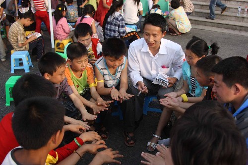 5月22日,一名志愿者在為孩子們講解高密度人群生活常識。