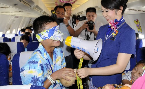6月16日,南航四川籍乘務(wù)長李冰茹在飛機上和孩子們做游戲。