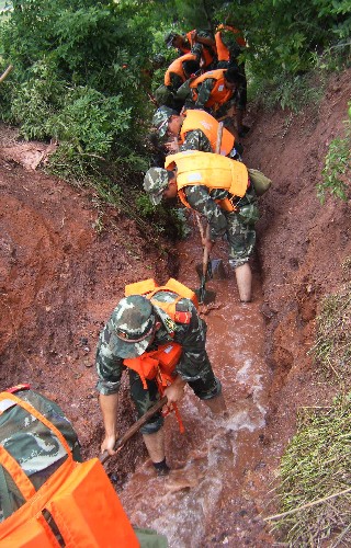 安徽休寧荷花塘水庫告急 武警官兵緊急挖掘泄洪槽 6月16日,武警安徽總隊(duì)黃山市支隊(duì)官兵在安徽休寧縣荷花塘水庫挖掘分流泄洪槽。 由于連日持續(xù)降雨,荷花塘水庫水位一度高出警戒水位,壩體多處出現(xiàn)滲水現(xiàn)象。武警黃山市支隊(duì)官兵于15日晚緊急趕赴水庫搶險(xiǎn)。截至16日下午1時(shí),搶險(xiǎn)官兵挖掘一條分流泄洪槽,荷花塘水庫水位整體下降,緩解了險(xiǎn)情。 新華社發(fā)