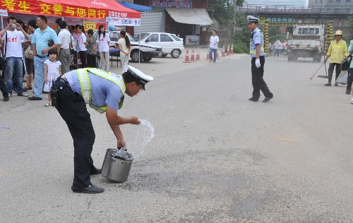 這是民警正在考場外的道路上灑水。