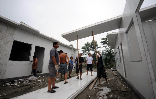 四川地震災(zāi)區(qū)已建成過渡安置房164萬套 7月4日,工人在四川省都江堰市建設(shè)活動(dòng)板房。 截至7月3日,四川全省累計(jì)建成過渡安置房164萬套(戶)。四川計(jì)劃8月12日前全部解決地震災(zāi)區(qū)群眾過渡安置問題。 新華社記者 聶建江 攝