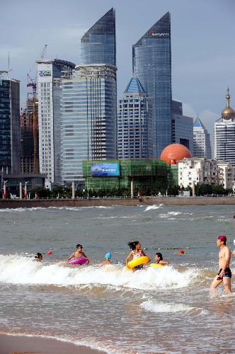 7月30日,人們?cè)诎舜箨P(guān)海水浴場(chǎng)游泳。
