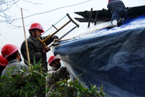 11月14日,四川什邡市規(guī)劃和建設(shè)局工作人員在給受災(zāi)群眾的過渡房搭圍子。