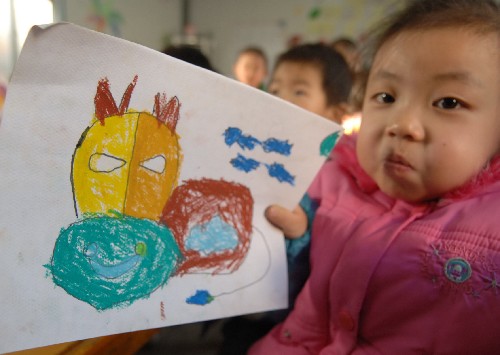 12月24日,陜西省略陽縣高臺小學幼兒園的孩子柯嘉琪展示自己的繪畫作品。新華社記者 陳鋼攝