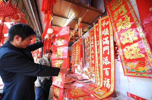 1月18日,一位市民正在挑選春聯(lián)。隨著新春佳節(jié)的臨近,昆明市的年貨市場開始升溫,年畫、燈籠、中國結(jié)、春聯(lián)、福字等春節(jié)飾品尤其受到市民歡迎,紅紅火火走俏市場。 新華社記者 秦晴 攝
