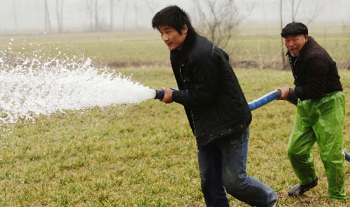 2月6日,安徽阜陽潁州區(qū)農(nóng)民在澆水抗旱。 自2008年10月下旬以來,安徽省阜陽市累計降水不足10毫米,是1953年以來同期降水最少、旱情最重的一年。該市668萬畝小麥遭受旱災(zāi),占播種面積的93%,其中重旱達300多萬畝。為此,阜陽市市委、市政府全面發(fā)動,全民動員,抗旱保苗。截至2月4日,該市已澆灌小麥458.3萬畝,追施小麥返青肥157.3萬畝。 新華社記者李健攝