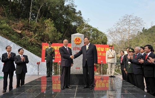 2月23日,國務(wù)委員戴秉國(左)和越南副總理兼外長范家謙在為1116號(hào)界碑揭幕后握手。 當(dāng)日,中越雙方在廣西憑祥友誼關(guān)口岸舉行儀式,共同慶祝陸地邊界勘界立碑圓滿結(jié)束。戴秉國國務(wù)委員和越南副總理兼外長范家謙分別代表兩國政府出席儀式并致辭。兩國外交、國防、公安、測(cè)繪、經(jīng)濟(jì)部門和邊境地方政府代表400余人參加了慶?;顒?dòng)。 新華社記者 周華 攝