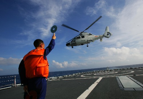 “廣州”艦引導(dǎo)員在甲板上引導(dǎo)直升機(jī)起降(2月23日攝)。 2月23日,赴巴基斯坦參加“和平-09”海上多國聯(lián)合軍事演習(xí)的中國海軍“廣州”號導(dǎo)彈驅(qū)逐艦,在南中國海海域進(jìn)行了“直-九”型艦載直升機(jī)甲板起降訓(xùn)練。 新華社記者 查春明 攝