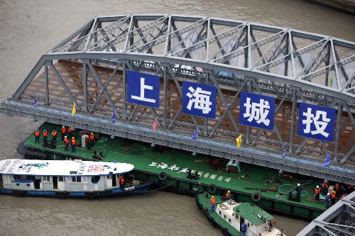 2月26日,外白渡橋南跨橋體正“乘坐”駁船“回家”。 新華社記者裴鑫攝