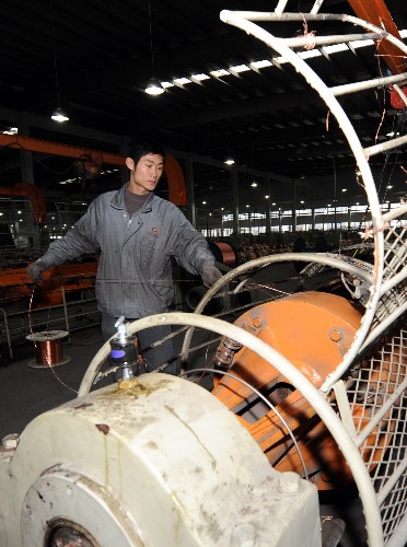 2月26日,江蘇常熟中利科技的一位工人在巡查電纜生產線。新華社記者 姜帆 攝