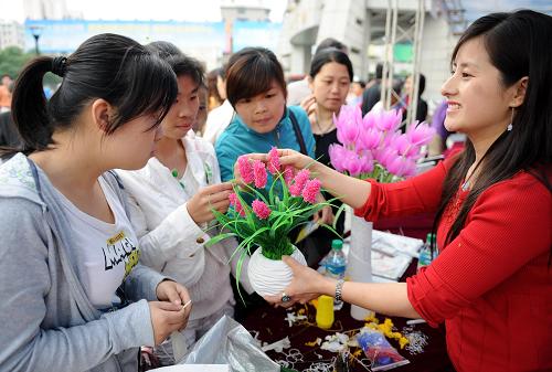 5月27日,招聘會(huì)上一位創(chuàng)意絲網(wǎng)花項(xiàng)目工作人員在向求職者介紹絲網(wǎng)花手工藝制作。當(dāng)日,南昌市西湖區(qū)舉辦2009年重點(diǎn)項(xiàng)目暨創(chuàng)意人才專場(chǎng)招聘會(huì),為返城回鄉(xiāng)務(wù)工人員及高校畢業(yè)生搭建就業(yè)平臺(tái)。據(jù)了解,招聘會(huì)共有43個(gè)重大項(xiàng)目的建設(shè)企業(yè)和12個(gè)創(chuàng)業(yè)推介項(xiàng)目,為求職者提供2200多個(gè)就業(yè)崗位。新華社發(fā)(周科攝)