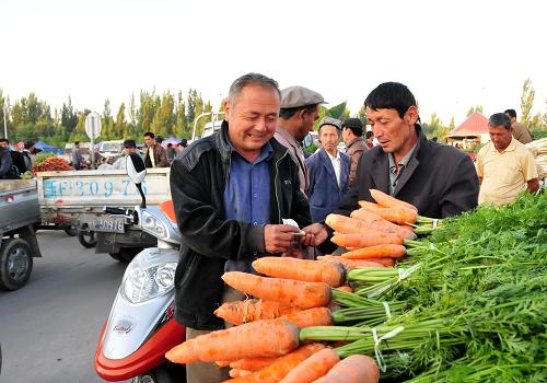 7月21日,商販在集市上采購(gòu)蔬菜。新華社記者 李紫恒 攝