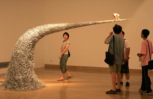 7月23日,觀眾在北京中國美術(shù)館舉行的海峽兩岸當(dāng)代藝術(shù)展展廳欣賞雕塑作品《太遠(yuǎn)》。 當(dāng)日,“講·述——2009海峽兩岸當(dāng)代藝術(shù)展”在北京中國美術(shù)館開展。海峽兩岸藝術(shù)家的58組件作品參展,展覽分為歷史與記憶、現(xiàn)實(shí)與反思、個(gè)人經(jīng)驗(yàn)與公共空間三個(gè)主題,作品涵蓋平面繪畫、雕塑、裝置、攝影、影像等內(nèi)容。 新華社發(fā)(趙冰 攝)