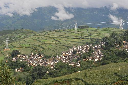 小灣電站新架設(shè)的輸電線路通過山區(qū)村寨( 7月22日攝)。新華社記者 陳海寧 攝
