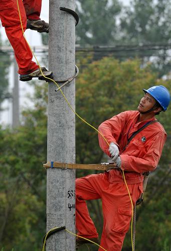 7月23日,簡義軍和同事一起進行電路改造施工。新華社記者 王雷 攝