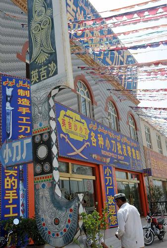 7月23日,一位顧客從碩大的英吉沙小刀模型旁經(jīng)過,走進(jìn)一家英吉沙小刀專賣店。 新疆喀什地區(qū)英吉沙縣已有數(shù)百年生產(chǎn)維吾爾族工藝小刀的歷史。近年來,伴隨英吉沙旅游事業(yè)發(fā)展,造型精致、制作精巧的英吉沙工藝小刀深受中外游客喜愛,英吉沙小刀因此被當(dāng)?shù)卣鳛槊褡逄厣に嚻讽椖恐攸c扶持,如今該縣英吉沙小刀大小作坊有1200多家,街頭的銷售店鋪攤點也是隨處可見。新華社記者周文杰攝