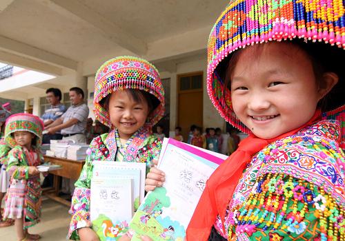 8月31日,么窩希望小學(xué)女童班的王橋(右一)小朋友領(lǐng)到免費(fèi)教科書。新華社發(fā)(林斌 攝)