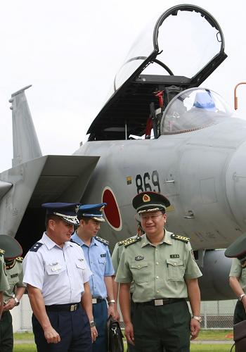 9月4日,在日本東京北部的百里基地,日本航空自衛(wèi)隊第七航空團兼百里基地司令荒木淳一少將(前左一)陪同到訪的中國人民解放軍中青年軍官研修團團長、中國國防部外事辦公室政治部主任呂讓全(前右一)大校參觀F-15戰(zhàn)斗機。新華社記者任正來攝