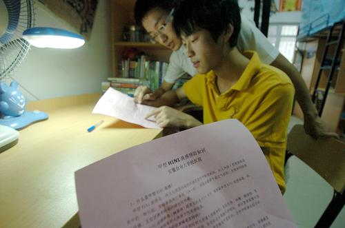 9月8日,安徽農(nóng)業(yè)大學(xué)學(xué)生張素林(前)和同學(xué)田夕在宿舍內(nèi)閱讀校醫(yī)院發(fā)放的甲型H1N1流感預(yù)防知識(shí)單。新華社發(fā)(郭晨 攝)