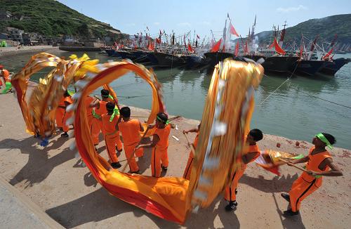 9月13日,浙江舟山市嵊泗縣黃龍鄉(xiāng)漁民在停滿漁船的南港碼頭舞龍祈福。新華社發(fā)(吳琳紅 攝)