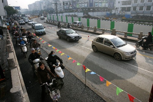 12月26日,在蘇州軌道交通一號線施工區(qū)域旁,機(jī)動(dòng)車和非機(jī)動(dòng)車?yán)@道行駛。 新華社發(fā)(戚振林 攝)