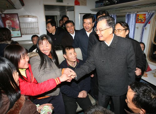 1月30日,中共中央政治局常委、國(guó)務(wù)院總理溫家寶在廣州火車站看望旅客。這是溫家寶總理登上一列即將發(fā)往南昌的火車與旅客交談?!⌒氯A社記者 姚大偉 攝
