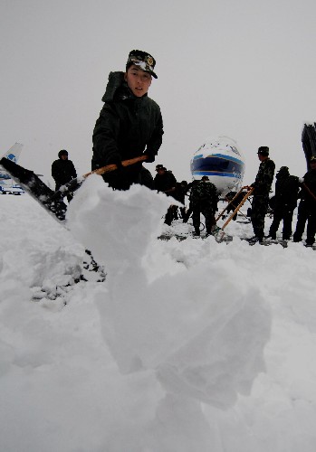 2月2日,浙江公安邊防總隊杭州邊檢站的戰(zhàn)士們在蕭山機(jī)場跑道上鏟雪。 新華社記者 黃深鋼 攝