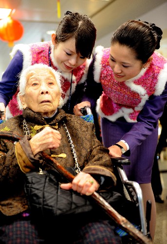 2月4日,廈門航空公司地勤人員在護(hù)送106歲的臺(tái)胞林梅登機(jī)前往臺(tái)北過年。 當(dāng)日13時(shí),兩岸春節(jié)包機(jī)廈門航點(diǎn)MF881航班班機(jī)滿載203名旅客由廈門高崎國(guó)際機(jī)場(chǎng)首飛臺(tái)北。廈航今年春節(jié)包機(jī)在2月4日至12日期間分別執(zhí)行廈門-臺(tái)北、廈門-高雄6個(gè)往返航班。 新華社記者 張國(guó)俊 攝