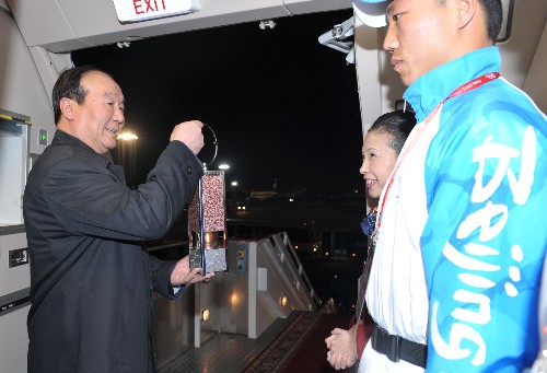 4月4日,北京奧組委執(zhí)行副主席蔣效愚(左)從奧運圣火護衛(wèi)隊隊員手中接過圣火火種燈準備走出機艙。當(dāng)日,載有北京奧運圣火的專機“奧運圣火號”到達此次環(huán)球火炬?zhèn)鬟f的第三站――圣彼得堡。 新華社記者 安治平 攝