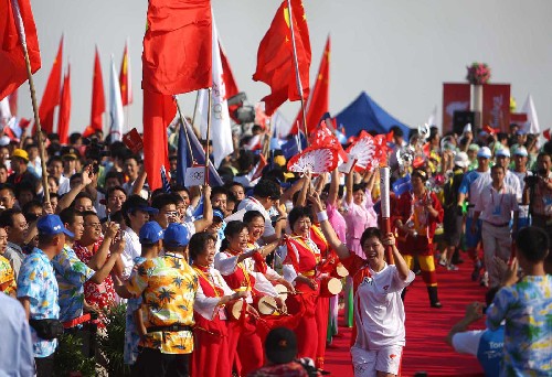5月6日,奧運火炬手王麗芳手持火炬?zhèn)鬟f。當(dāng)日,北京奧運圣火傳遞活動在海南省??谑信e行。 新華社記者 邢廣利 攝