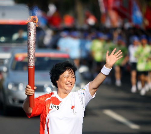 5月6日,奧運火炬手符桂花手持火炬?zhèn)鬟f。當(dāng)日,北京奧運圣火傳遞活動在海南省??谑信e行。 新華社記者邢廣利攝