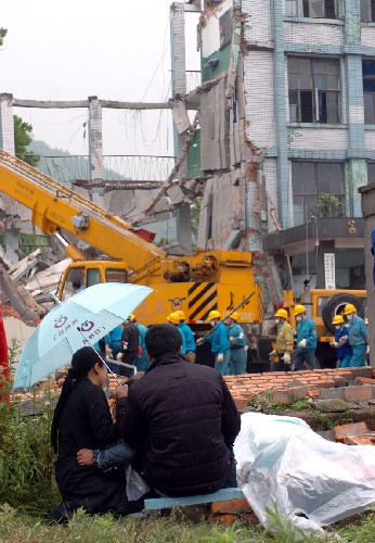 5月13日,在倒塌的綿竹市漢旺鎮(zhèn)東汽中學(xué),一對父母在孩子的遺體旁哭泣。 新華社記者 苑堅(jiān) 攝