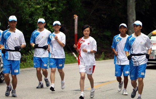 5月15日,奧運火炬手林嬋手持火炬?zhèn)鬟f。當日,北京奧運圣火傳遞活動在江西井岡山舉行。 新華社記者 邢廣利 攝