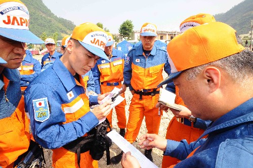 5月16日上午9點(diǎn)45分,首批31名日本專業(yè)救援人員抵達(dá)距成都近400公里的青川縣關(guān)莊鎮(zhèn)。由于距離山體滑坡搜救地點(diǎn)5公里處道路沒有打通,搜救人員只能暫時(shí)原地待命。日本救援人員表示:“只要有一線希望,我們就會(huì)努力到最后一刻。” 這是日本救援人員在緊急協(xié)商是否更換搜救地點(diǎn)。 新華社記者 李濤 攝