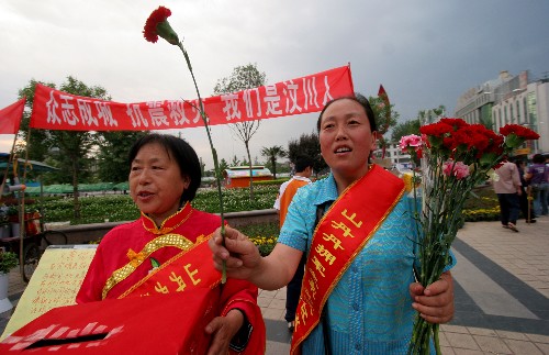 5月16日,陜西省咸陽市擁軍模范、“山丹丹擁軍之家”創(chuàng)辦人張娟娟(右一)和志愿者一起在咸陽市人民廣場上義賣鮮花,幫助地震災(zāi)區(qū)。從5月15日開始,張娟娟就和“擁軍之家”的志愿者一道在街頭義賣鮮花,并將義賣所得寄給中國紅十字總會。 新華社發(fā)(何建虎 攝)