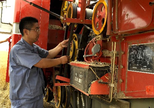 5月25日,在河南省鎮(zhèn)平縣郭營村,農(nóng)機(jī)技術(shù)人員為外地“麥客”免費(fèi)維修收割機(jī)械。 新華社記者 王頌 攝