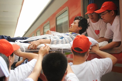 5月27日,志愿者在石家莊火車站將傷員抬下火車。 當(dāng)日,首批到河北接受治療的77名四川汶川大地震受傷傷員由四川廣元乘坐專列抵達(dá)石家莊。這些傷員將被安置在石家莊市各大醫(yī)院接受治療。 新華社記者 楊世堯 攝
