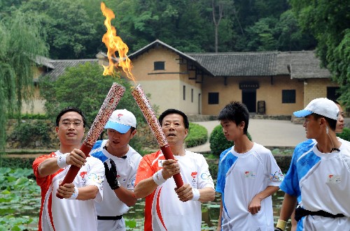 6月5日,在毛澤東故居前,火炬手毛雨時(在三)與下一棒火炬手謝振華交接。當(dāng)日,北京奧運圣火在湖南韶山傳遞。 新華社記者趙眾志 攝