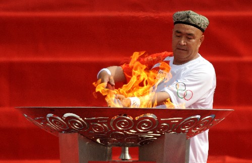 6月18日,火炬手達(dá)吾提·阿西木點(diǎn)燃圣火盆。當(dāng)日,北京奧運(yùn)圣火在新疆喀什傳遞。 新華社記者 趙戈 攝