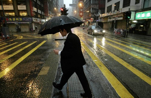 6月25日清晨,香港市民冒著風(fēng)雨趕路。由于臺(tái)風(fēng)“風(fēng)神”在香港附近集結(jié),香港天文臺(tái)6月24日22時(shí)45分發(fā)出8號(hào)風(fēng)球(暴風(fēng)信號(hào)),并于6月25日6時(shí)發(fā)出紅色暴雨警告信號(hào)。香港部分公共交通受到影響,所有學(xué)校停課。 新華社記者 周磊 攝