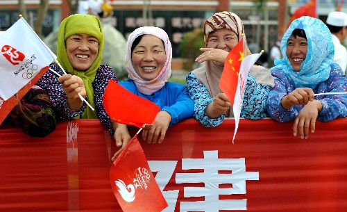 6月30日,當?shù)馗髯迦罕姙榛鹁鎮(zhèn)鬟f加油。當日,北京奧運圣火在寧夏吳忠傳遞。 新華社記者 王鵬 攝