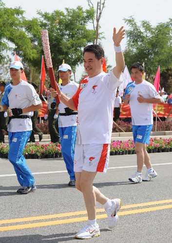 6月30日,火炬手夏林手持火炬?zhèn)鬟f。當日,北京奧運圣火在寧夏吳忠傳遞。 新華社記者 安治平 攝
