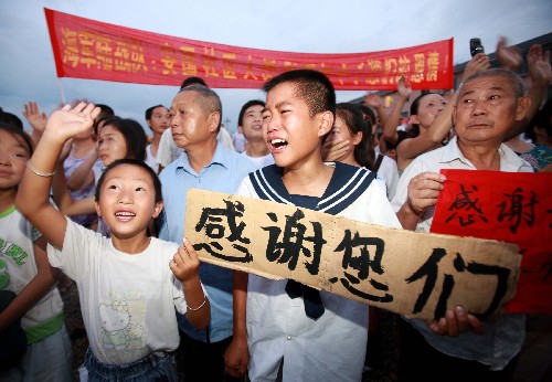 7月23日,一名災(zāi)區(qū)的孩子在歡送的人群中失聲哭泣。 新華社記者 查春明 攝